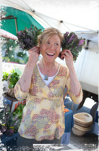 Susie Sutphin smiling while holding bunches of lavender